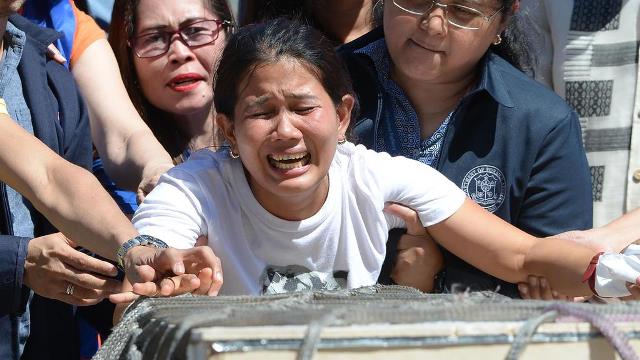 jessica sister of filipina housemaid joanna demafelis whose body was found inside a freezer in kuwait cries in front of the wooden casket containing her sister 039 s remains at the international airport in manila on february 16 2018 photo afp