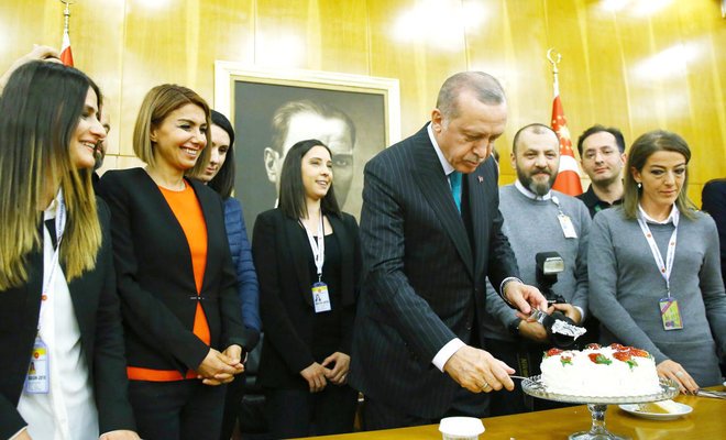 turkish president recep tayyip erdogan cuts a cake offered by reporters on his 65th birthday shortly before departing for a five day african tour in istanbul on monday photo afp