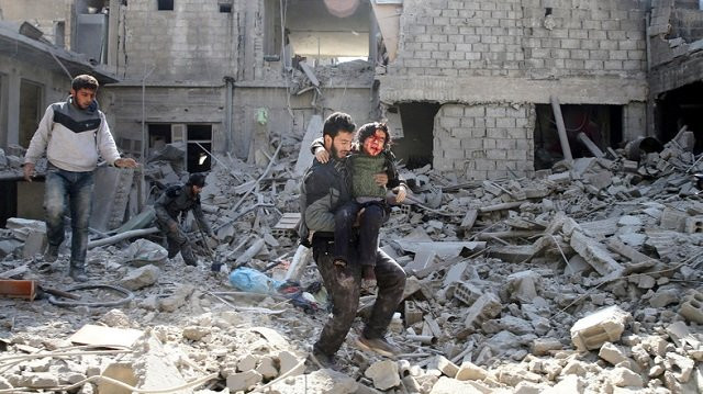 a man carries an injured boy as he walks on rubble of damaged buildings in the rebel held besieged town of hamouriyeh eastern ghouta near damascus syria february 21 2018 photo reuters a man carries an injured boy as he walks on rubble of damaged buildings in the rebel held besieged town of hamouriyeh eastern ghouta near damascus syria february 21 2018 photo reuters
