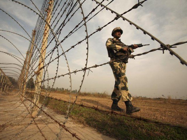 india has been justifying the stationing of over 700 000 troops in iok an indian border security force soldier patrols near the fenced border with pakistan photo reuters file