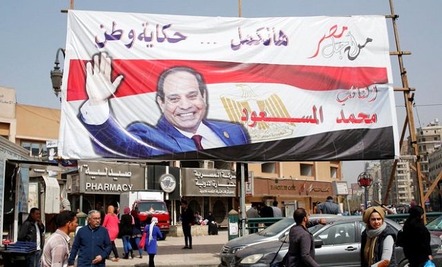 people walk by a poster of egypt 039 s president abdel fattah al sisi for the upcoming presidential election in cairo egypt march 1 2018 the poster reads quot story of the country will continue with you quot presidential elections will be held in egypt between 26 and 28 march 2018 photo reuters