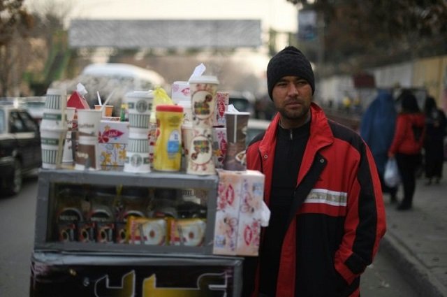 file photo of najibullah sharyari waiting for customers at his coffee cart in kabul january 8 2018 photo afp file