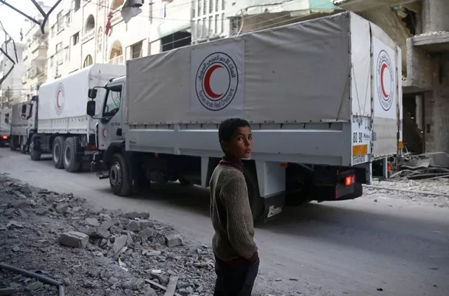 a boy stands as an aid convoy of syrian arab red crescent drives through the besieged town of douma eastern ghouta damascus syria march 5 2018 photo reuters a boy stands as an aid convoy of syrian arab red crescent drives through the besieged town of douma eastern ghouta damascus syria march 5 2018 photo reuters