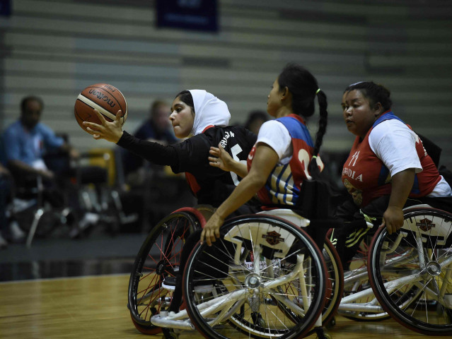 a member of afghanistan 039 s women 039 s wheelchair basketball team in black battles for the ball against cambodia during the qualifying tournament for the asia para games in bangkok photo afp