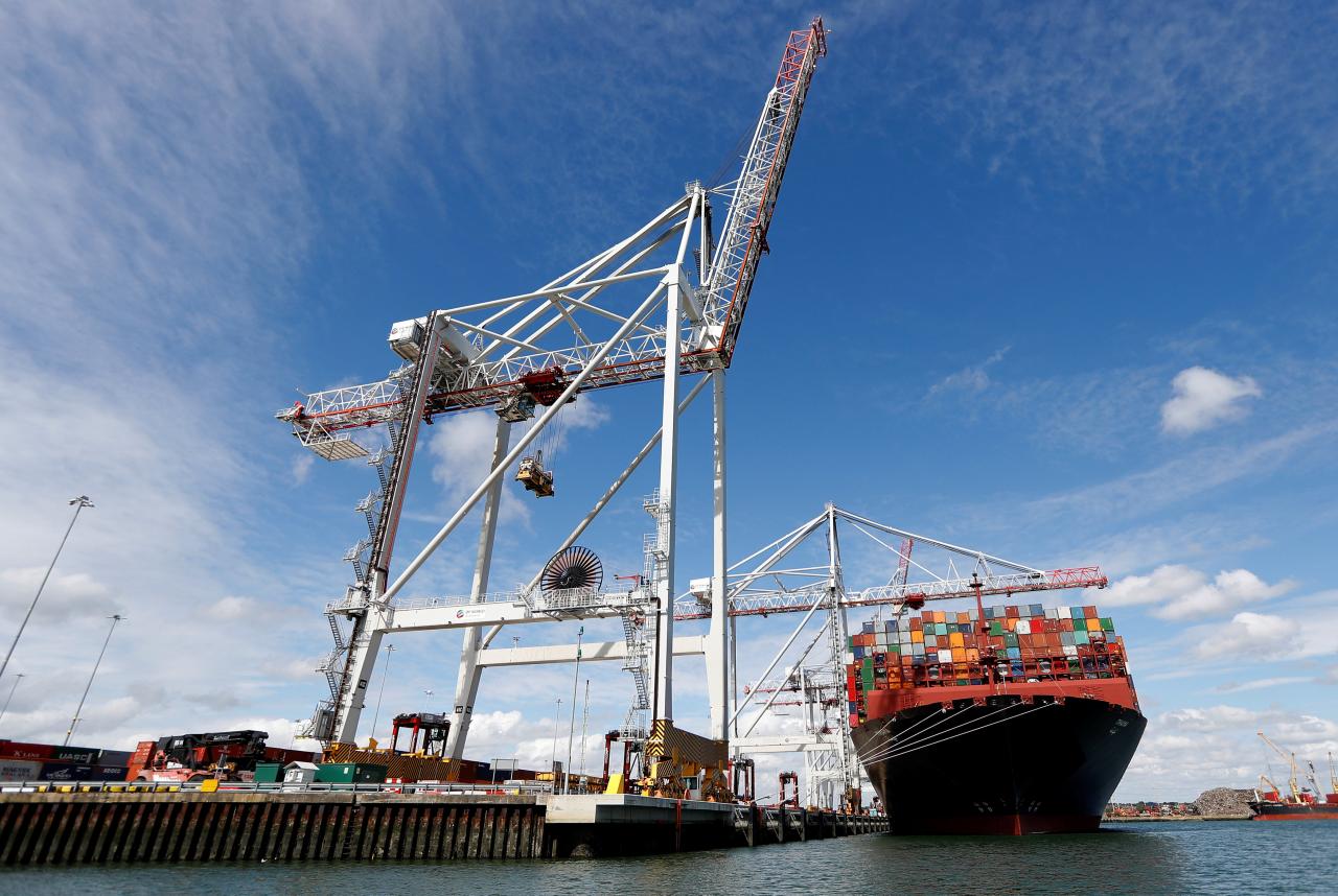 shipping containers are stacked on a cargo ship in a dock photo reuters