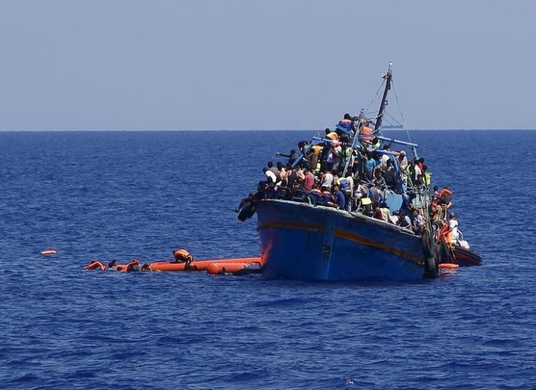 migrants hang onto flotation tubes in the sea after jumping from an overloaded wooden boat during a rescue operation photo reuters