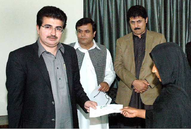 faisalabad march 10   muhammad sadiq sanjrani chief coordinator prime minister s grieval wing distributing the cheques among the poor and needy persons of faisalabad on behalf of honourable prime minister at wapda rest house photo online