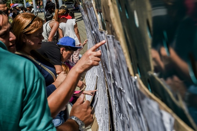 colombian voters check the electoral rolls at a polling station in medellin during elections to select a new congress with rightist candidates bitterly opposed to the peace deal with leftist rebels expected to do well photo afp