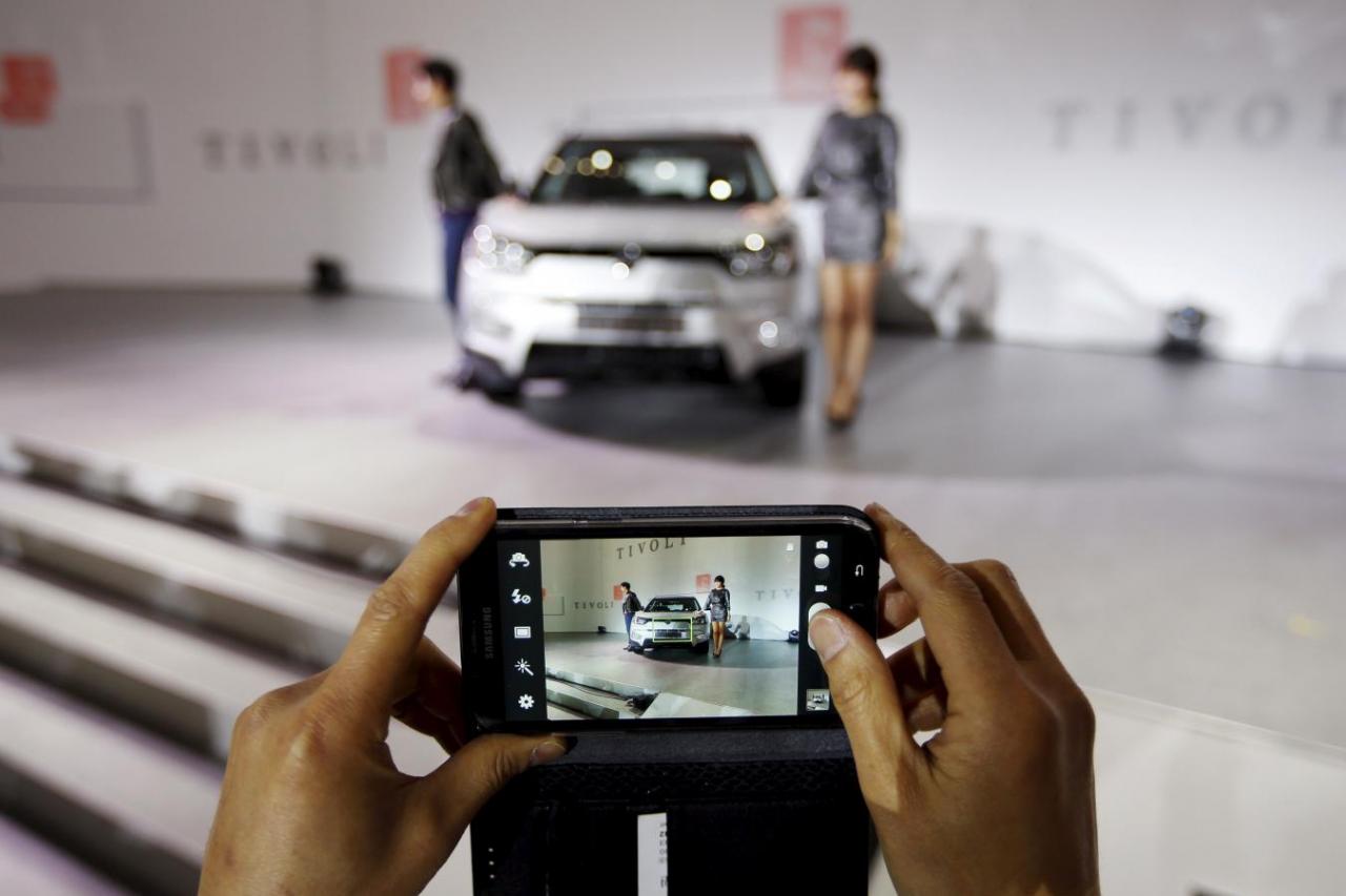 a man takes a photograph of ssangyong motor co 039 s tivoli during its launch ceremony in seoul in this january 13 2015 file photo photo reuters