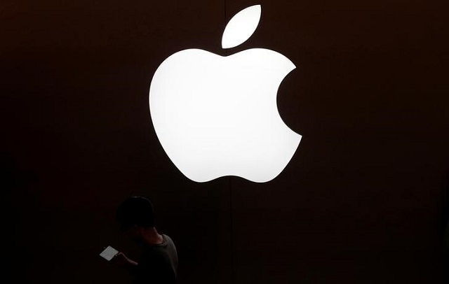 a man looks at the screen of his mobile phone in front of an apple logo outside its store in shanghai china july 30 2017 photo reuters