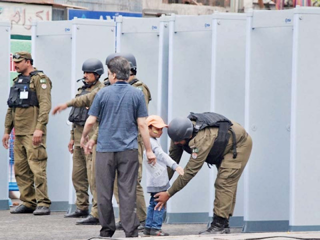 a policeman frisks a minor boy at the entrance of the stadium photo nni a policeman frisks a minor boy at the entrance of the stadium photo nni