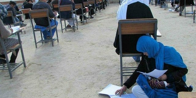 taab got off her seat and sat on the ground to nurse the baby all the while continuing to solve her exam photo courtesy afghan youth association gofundme