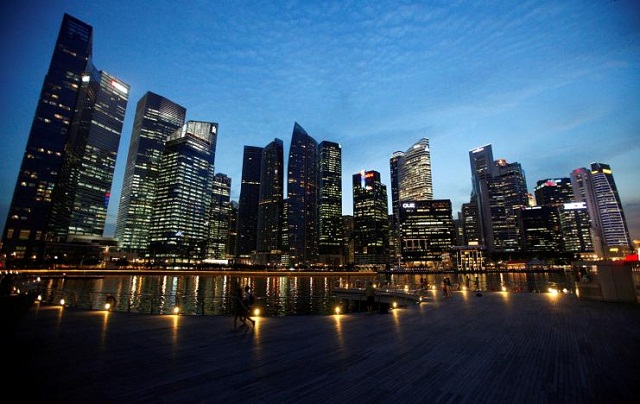 people walk past the skyline of marina bay central business district in singapore photo reuters