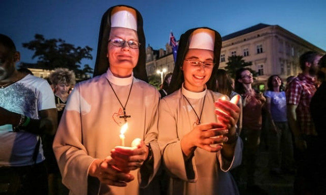 two pilgrims hold candles at world youth day in krakow poland photo courtesy the guardian two pilgrims hold candles at world youth day in krakow poland photo courtesy the guardian
