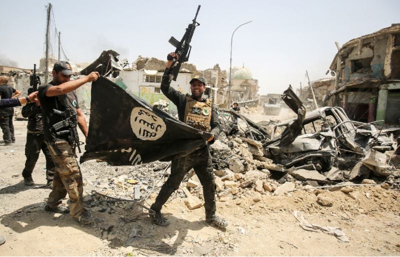 members of the iraqi forces cheer as they carry an upside down flag of the islamic state is group in mosul photo afp