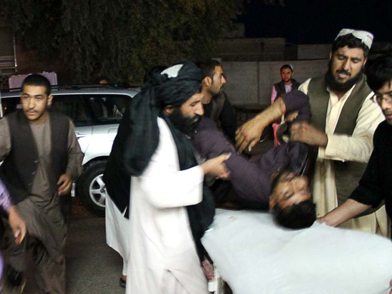 men carry a wounded man onto a stretcher outside a hospital following a car bomb in lashkar gah the capital of helmand province on march 23 2018 photo afp
