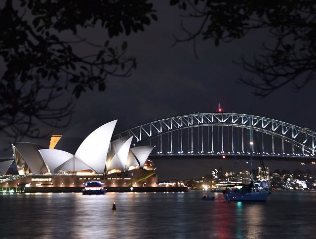 a photo shows the sydney harbour bridge and opera house being plunged into darkness for the earth hour environmental campaign on march 24 2018 photo afp