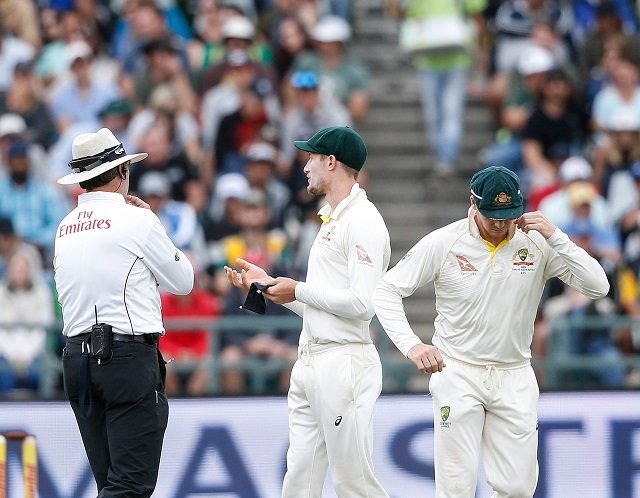 australian fielder cameron bancroft r is questioned by umpires richard illingworth l and nigel llong not in picture during the third day of the third test cricket match between south africa and australia at newlands cricket ground on march 24 2018 in cape town photo afp