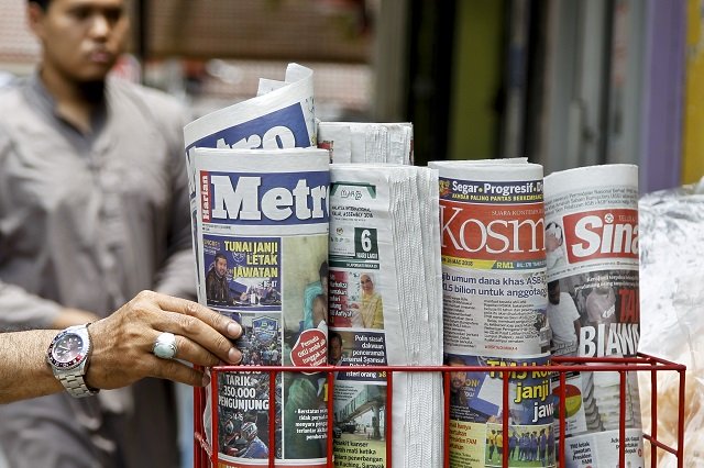 a man takes a copy of newspaper at a grocery shop in shah alam malaysia photo afp