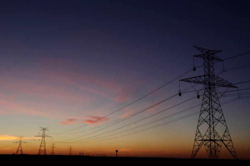 the sun sets behind power lines photo reuters