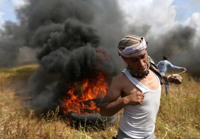 a palestinian runs during clashes with israeli troops during a tent city protest along the israel border with gaza photo reuters