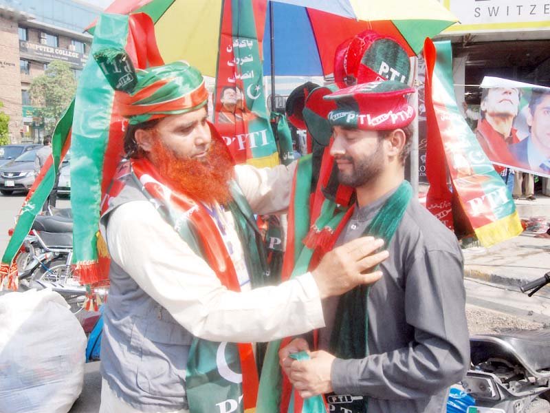 the pakistan tehreek e insaf supporters adorn themselves with the party s colours at liberty chowk photo nni