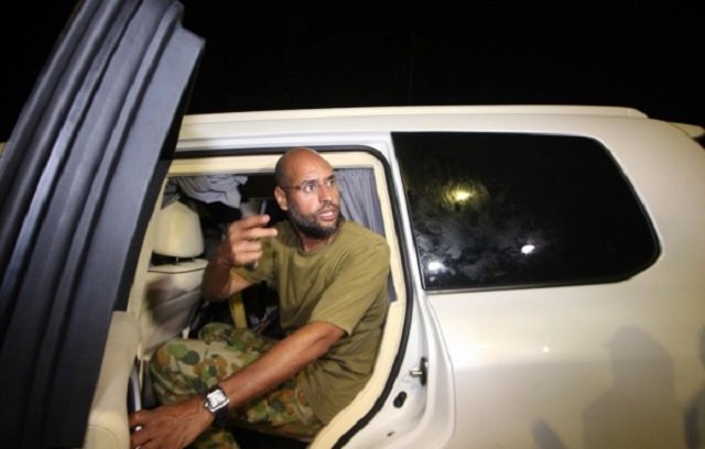 this file photo taken on august 23 2011 shows seif al islam gaddafi son of libyan leader muammar gaddafi appearing in front of supporters and journalists at his father 039 s residential complex in the libyan capital tripoli photo afp