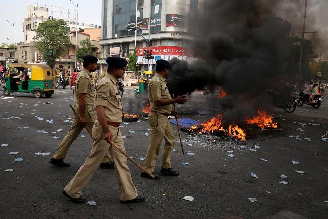 police officers patrol a street after people belonging to the dalit community burned tyres and hoardings during a nationwide strike called by dalit organisations in ahmedabad india april 2 2018 photo reuters