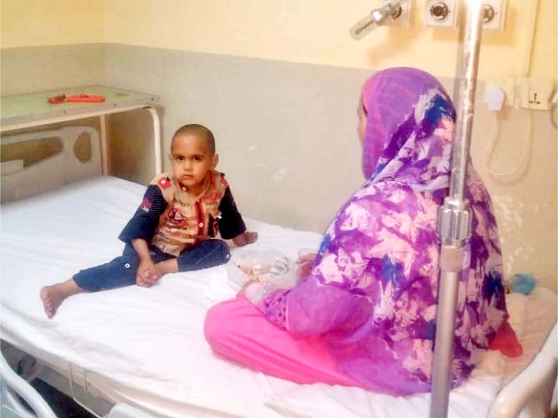 a woman tends to a child suffering from thallassemia at a hospital in islamabad photo express