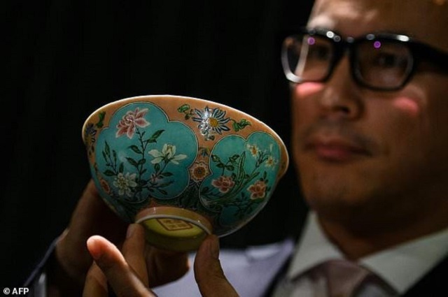 nicolas chow deputy chairman of sotheby 039 s asia holds an extremely rare qing dynasty bowl   one of only three known to exist   during a media preview it sold for 30 4 million photo afp