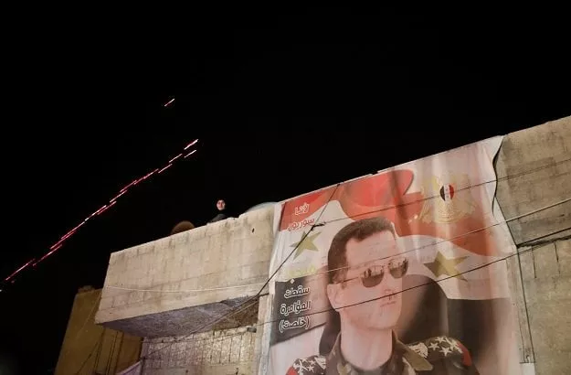 a poster of syrian president bashar al assad is seen as a woman watches while buses carrying freed hostages and rebels who were evacuated from the rebel held city of douma arrive at wafideen camp in damascus syria photo reuters a poster of syrian president bashar al assad is seen as a woman watches while buses carrying freed hostages and rebels who were evacuated from the rebel held city of douma arrive at wafideen camp in damascus syria photo reuters