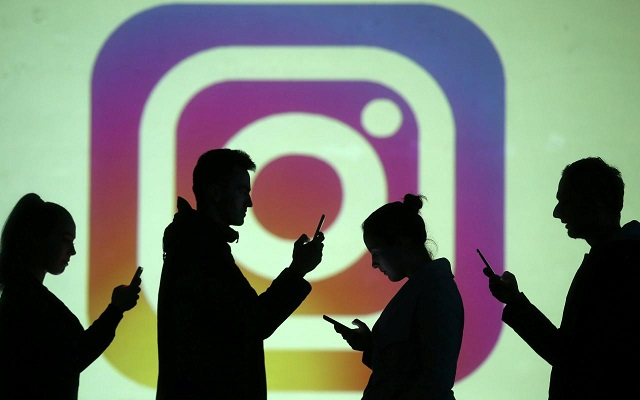 silhouettes of mobile users are seen next to a screen projection of instagram logo in this picture illustration taken march 28 2018 photo reuters