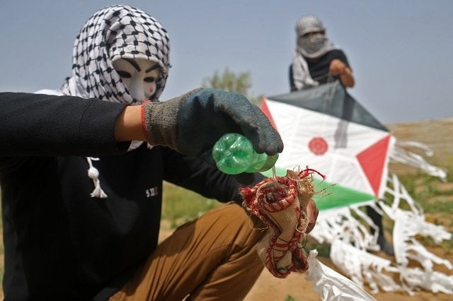 the kites carry notes in fire lit empty coke bottles photo afp the kites carry notes in fire lit empty coke bottles photo afp