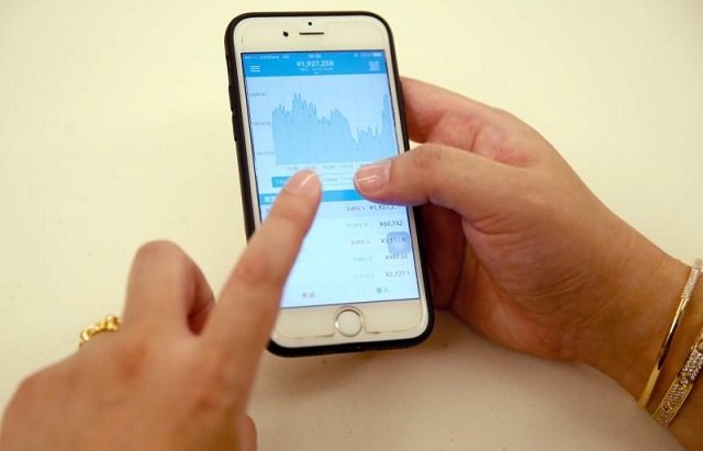 yoshinori kobayashi bitcoin trader demonstrates a bitcoin application on his mobile phone during an interview with reuters in tokyo japan december 12 2017 photo reuters