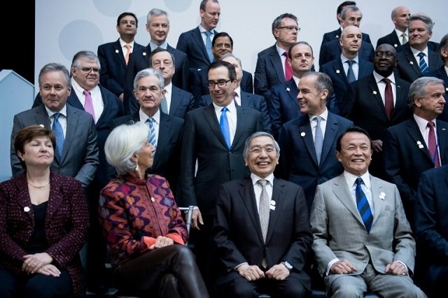 imf managing director christine lagarde who warned about rising protectionism looks to us treasury secretary steven mnuchin during a group photo of g 20 finance ministers and central bank governors photo afp