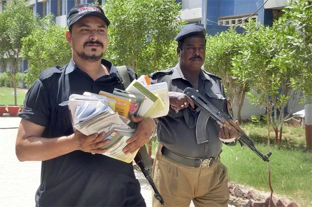 a security guard and policeman hold cheating material seized from an examination centre in hyderabad photo online a security guard and policeman hold cheating material seized from an examination centre in hyderabad photo online