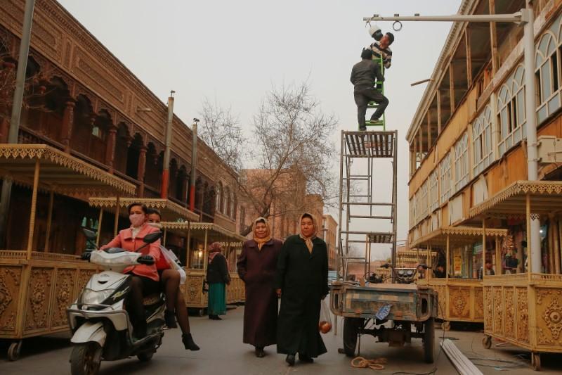 men install a cctv camera in a shopping street in the old town of kashgar xinjiang uighur autonomous region china photo reuters