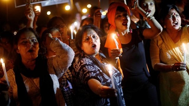 women hold candles as they shout slogans during a protest against the alleged rape of a 11 year old girl in ghaziabad in the outskirts of delhi on april 25 2018 photo reuters