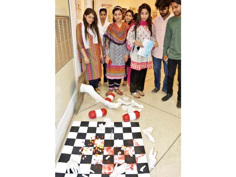 visitors examine one of the entries for the poster competition photo express