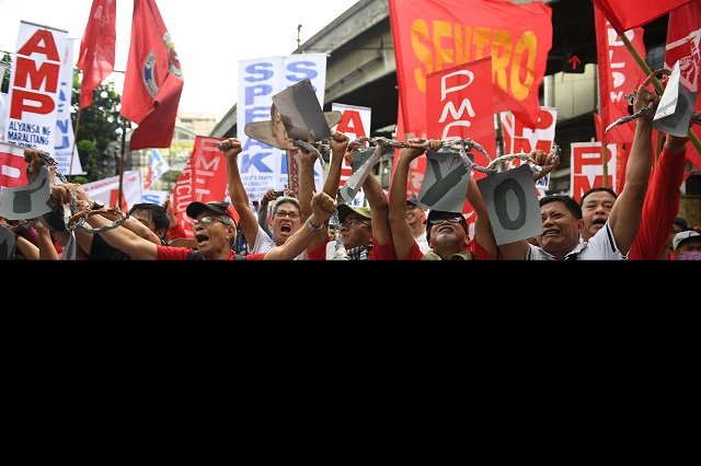 activists along with workers break a mock chain during the may day rally near malacanang palace photo afp