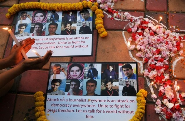 an indian photojournalist in kolkata holds a candle during a vigil for the 10 afghan journalists killed in monday 039 s suicide bombing photo afp