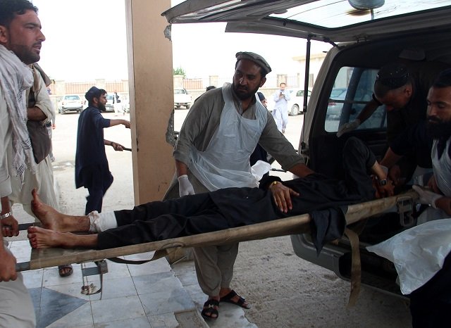 an afghan wounded man lays on a trolley as others rush him to a hospital following blast at a voter registration centre in khost province on may 6 2018 photo afp