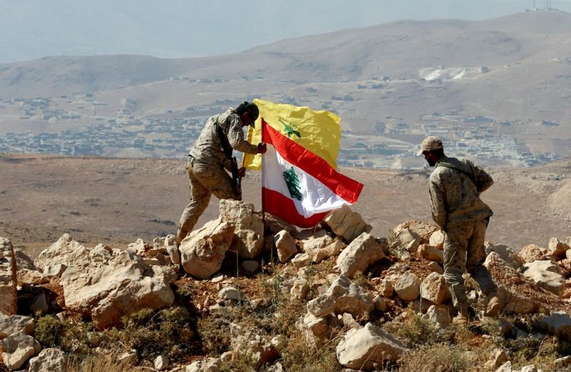 hezbollah fighters put lebanese and hezbollah flags at juroud arsal syria lebanon border photo reuters