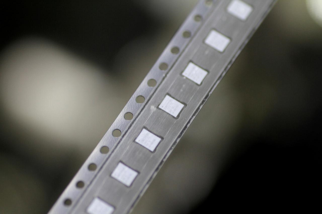 microchips emerge from a machine onto a roll in the clean room at the utac plant in singapore february 8 2018 photo reuters