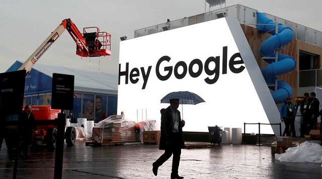 a man walks through light rain in front of the hey google booth under construction at the las vegas convention center in preparation for the 2018 ces in las vegas nevada us january 8 2018 photo reuters