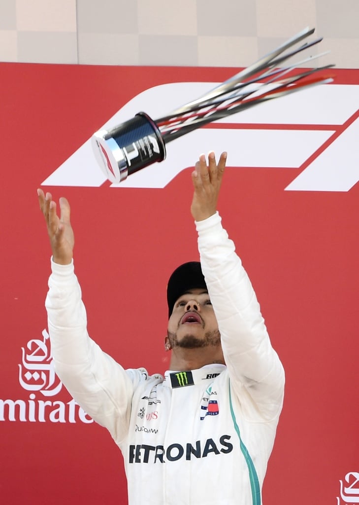 soaking it in mercedes 039 british driver lewis hamilton tosses his trophy on the podium after winning the spanish formula one grand prix race at the circuit de catalunya in montmelo photo afp