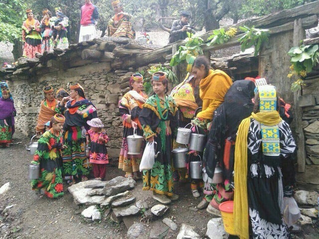 the women embellished in their traditional black robes ornate cowries shelled head dresses which are adorned with colored necklaces dance in circles photo courtesy tourism corporation of khyber pakhtunkhwa