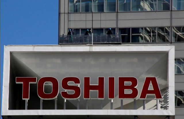 the logo of toshiba is seen as window cleaners work on the company 039 s headquarters in tokyo japan february 14 2017 photo reuters