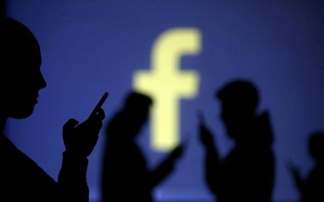 silhouettes of mobile users are seen next to a screen projection of facebook logo in this picture illustration taken march 28 2018 photo reuters silhouettes of mobile users are seen next to a screen projection of facebook logo in this picture illustration taken march 28 2018 photo reuters
