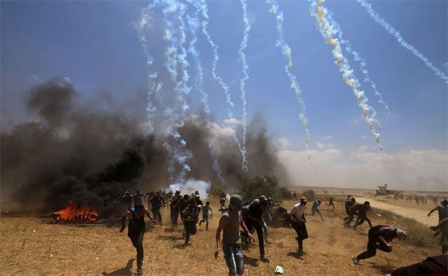 palestinian protesters run to take cover from tear gas fired by israeli troops near border in the southern gaza strip of khan younis photo xinhua palestinian protesters run to take cover from tear gas fired by israeli troops near border in the southern gaza strip of khan younis photo xinhua